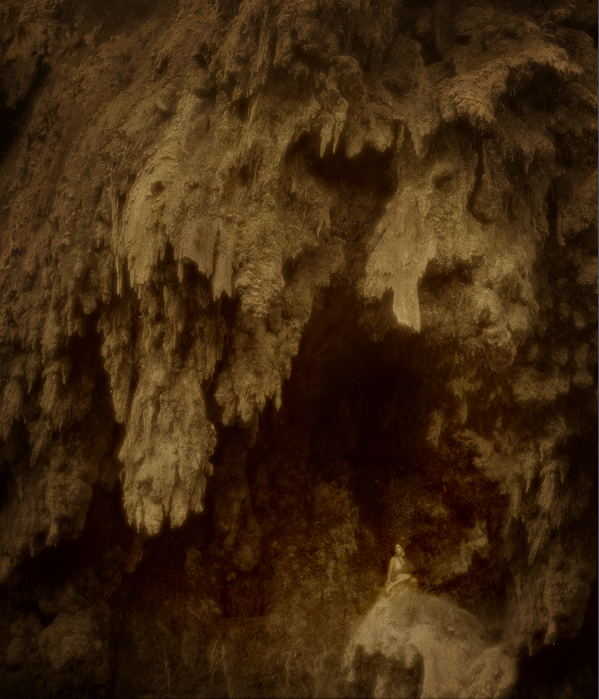 woman on cliff under stalactites