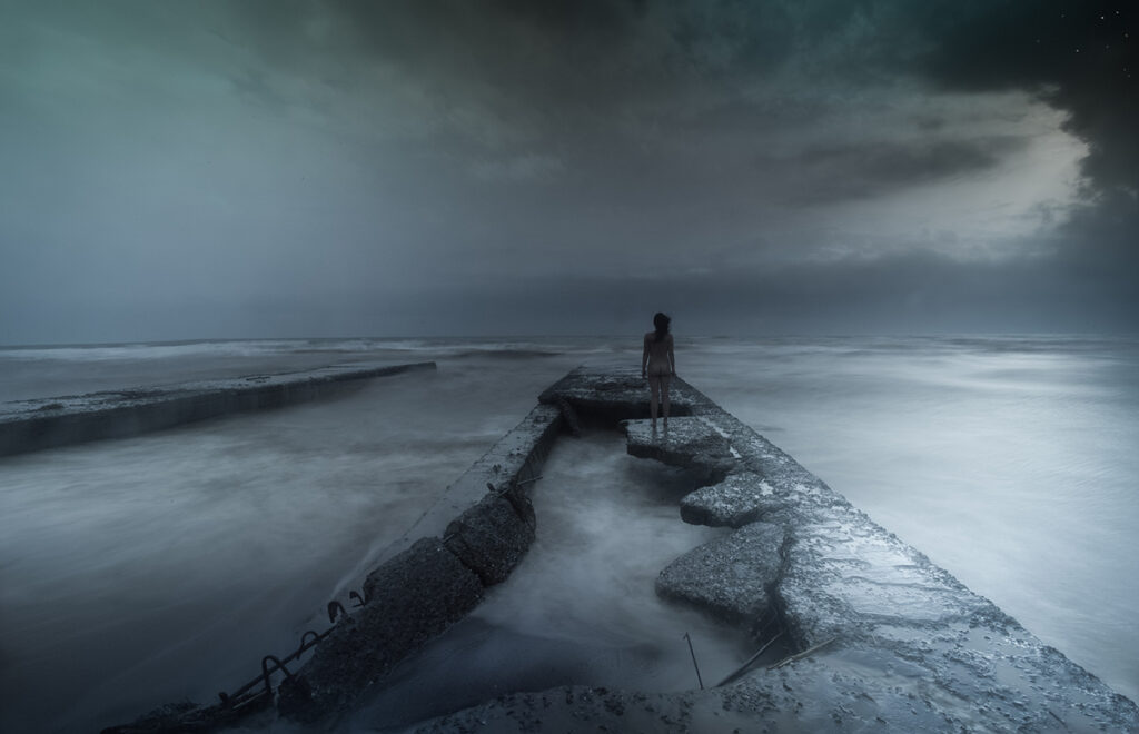 naked woman stands on jetty in storm