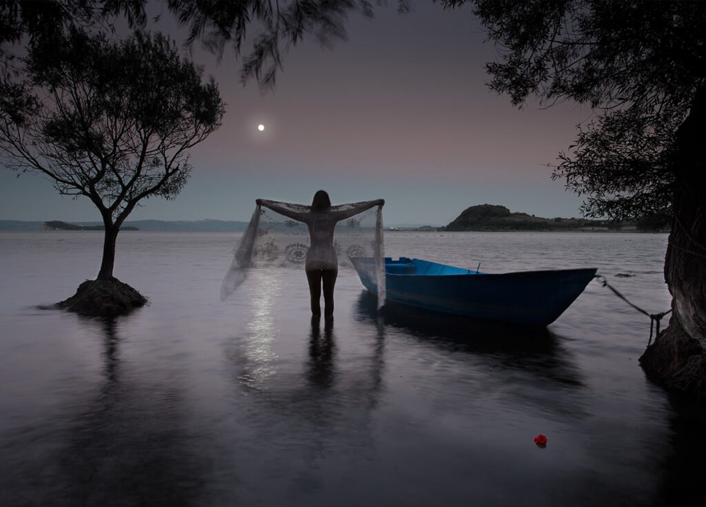 woman salutes the moon over lake